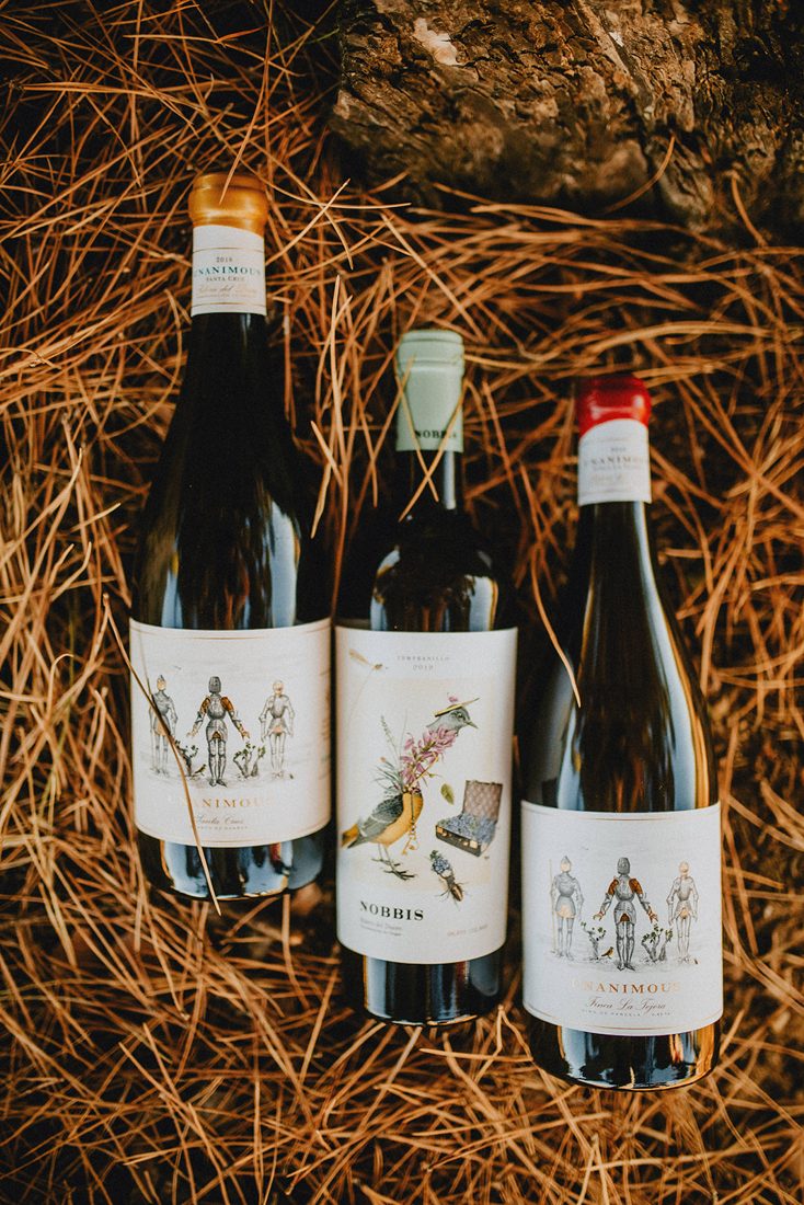 Bottles of Unanimous and Nobbis on pine needles